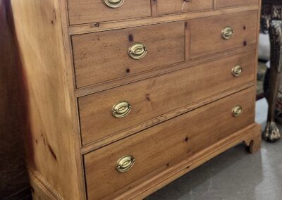 Wooden chest of drawers with brass handles.