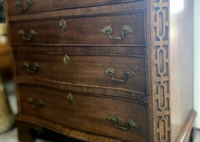 Vintage wooden dresser with ornate handles.