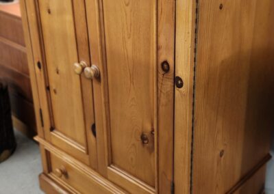 Wooden cabinet with closed doors and drawer.