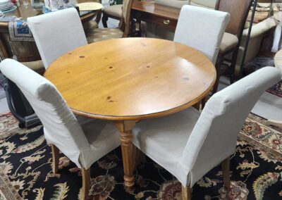 Round wooden table with four upholstered chairs.