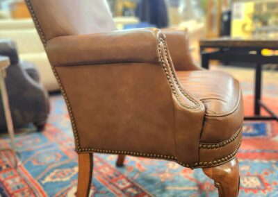 Brown leather chair on patterned rug.