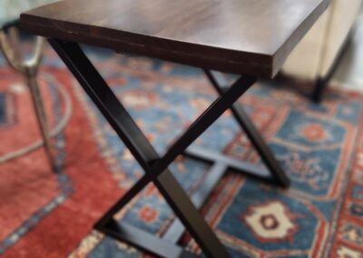 Wooden side table on patterned rug.