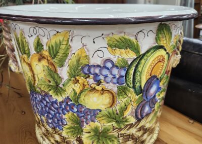 Decorative ceramic pot with fruit design.