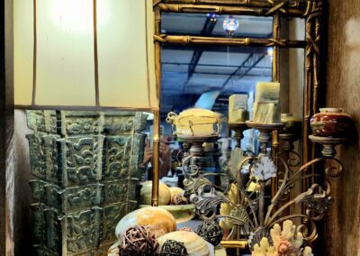 Decorative objects on wooden shelf with lamp.