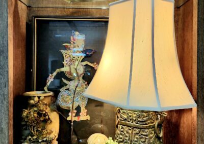 Wooden shelf with lamp and decorative items.