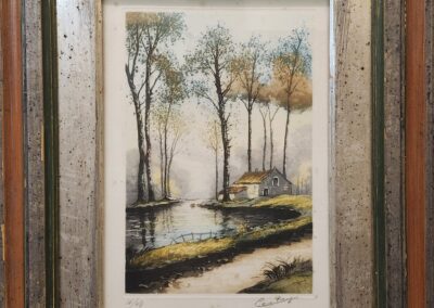 Framed landscape painting with house and trees.