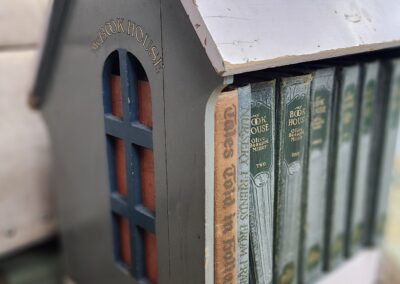 House-shaped bookshelf with vintage book spines.