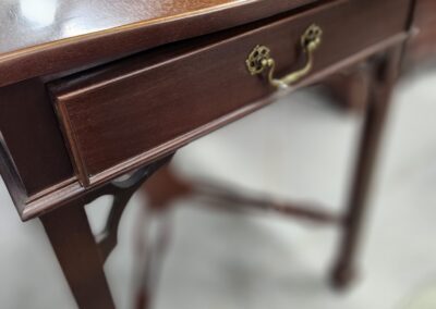 Wooden table with a single drawer handle.