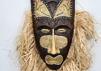 African tribal mask with straw fringe.