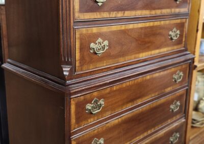 Vintage wooden dresser with ornate brass handles.