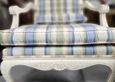 Plaid upholstered chair with carved wooden legs.