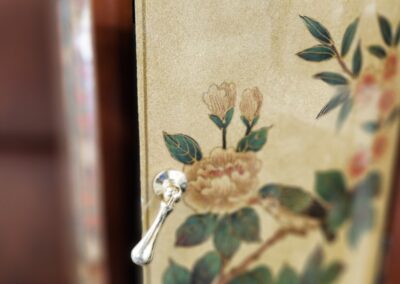 Ornate cabinet with floral design and handle.