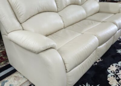 Beige leather sofa on patterned rug.