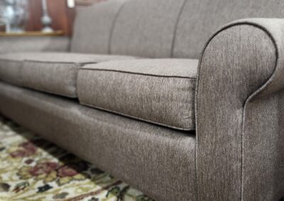 Brown sofa on patterned carpet in room.