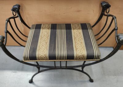 Decorative metal bench with striped cushion.