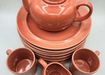 Red ceramic tea set with plates and cups.