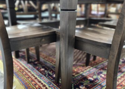 Wooden table and chairs on patterned rug.
