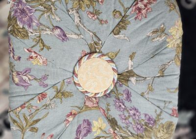 Floral-patterned cushion with central button detail.