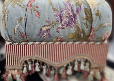 Floral cushion with striped tassel trim.