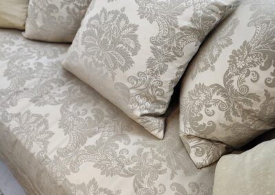 Decorative cushions on patterned beige sofa.