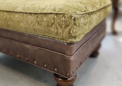 Ornate green and brown upholstered footstool.