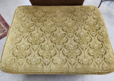 Patterned gold cushion on a chair seat.