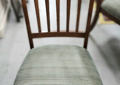 Wooden chair with striped upholstered seat.