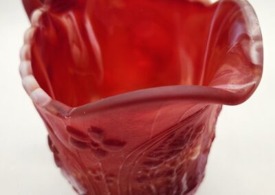Red decorative glass vase with floral design.