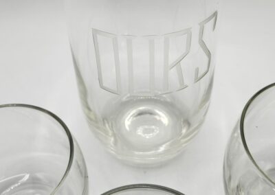 Glass pitcher and cups on white background.