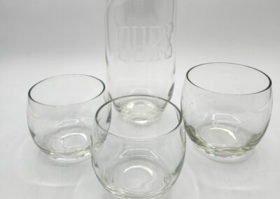 Glass pitcher with three round glasses.
