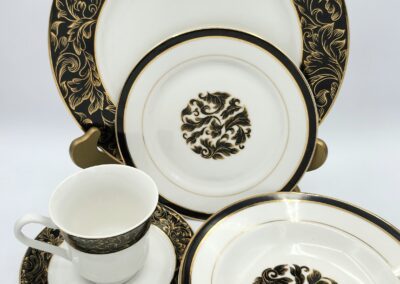 Elegant black and gold patterned dinnerware set.