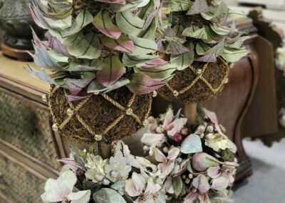 Decorative floral arrangements in ornate gold pots.