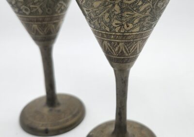 Two ornate brass goblets with floral design.