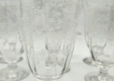 Etched crystal goblets with intricate floral patterns.