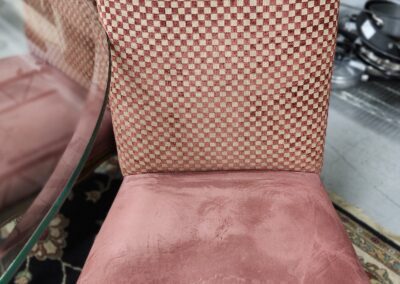 Checkered upholstered chair with pink seat cushion.