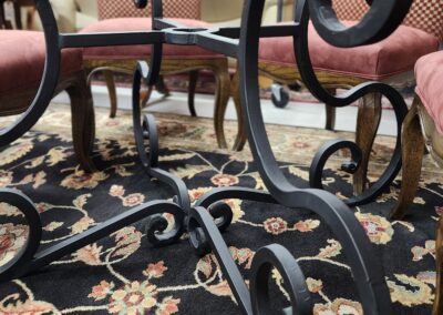 Ornate metal table base on floral rug.