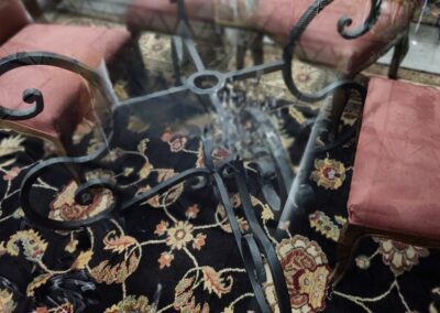 Glass table with red chairs and rug.