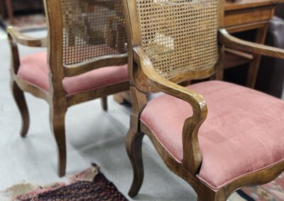 Vintage wooden chairs with pink cushions.