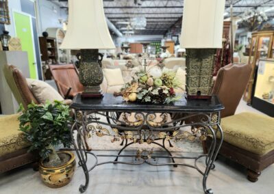 Antique table with decorative lamps and flowers.