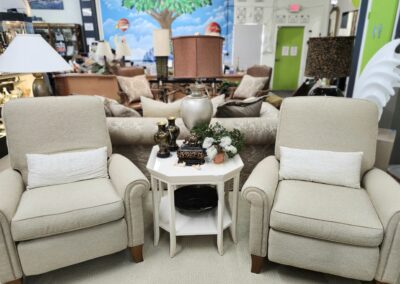 Two beige armchairs with decorative pillows.