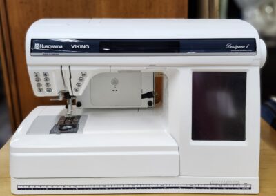 White sewing machine on wooden table.