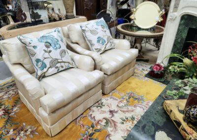 Two beige armchairs with floral cushions.