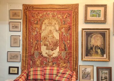 Gallery interior with paintings and plaid sofa.