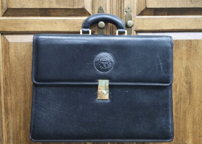 Black leather briefcase with embossed logo.