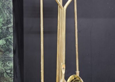 Brass fireplace tools on marble hearth.