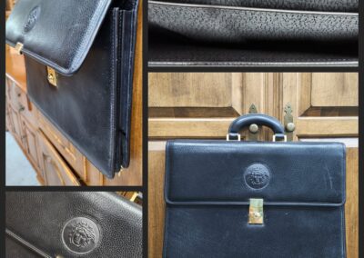 Black leather briefcase with embossed logo.