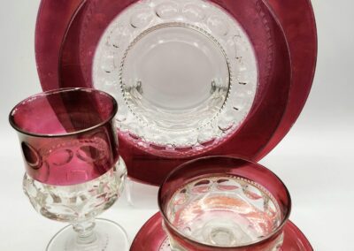 Red and clear glass dinnerware set display.
