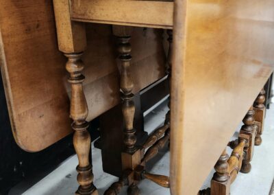 Wooden drop-leaf table with turned legs.