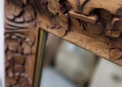 Carved wooden mirror frame with floral design.