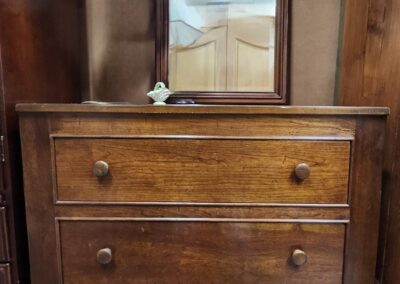Wooden dresser with attached mirror and drawers.